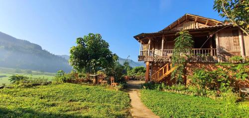 una casa en una colina al lado de un campo en La Beauté Bắc Hà en Bắc Hà