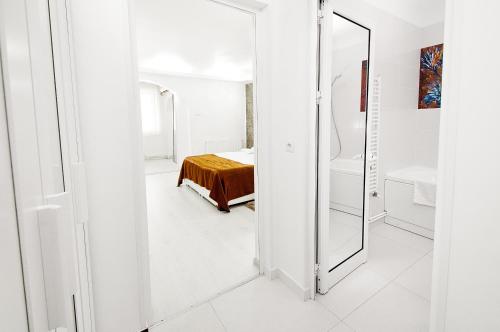 a white room with a mirror and a bed at Darin Aparthotel in Galaţi