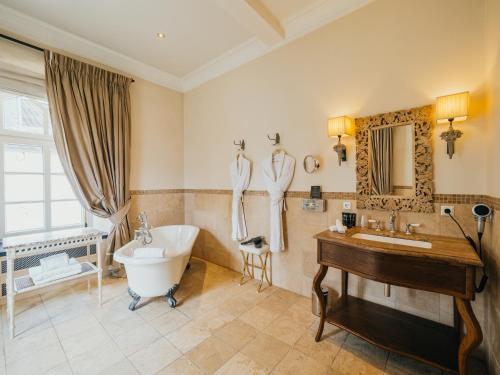 a bathroom with a tub and a sink and a bath tub at Chateau d'Urspelt in Urspelt