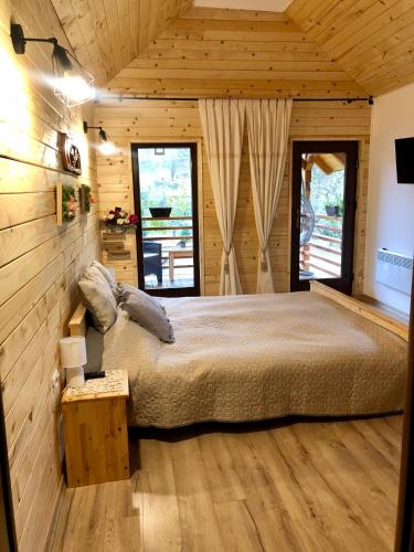 a bedroom with a large bed in a wooden room at Domeniul Horj Casa din Deal Moisei in Moisei