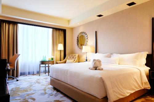 a hotel room with a large bed with a stuffed animal on it at AYANA Midplaza JAKARTA in Jakarta
