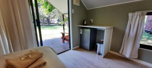 a bedroom with a door open to a porch with a sliding glass door at Coral Divers in Sodwana Bay
