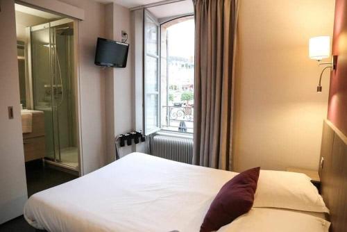 Habitación de hotel con cama y ventana en HOTEL DU COMMERCE, en La Châtre