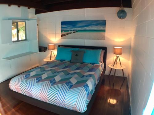 a bedroom with a bed with two lamps on it at High Tide at Emerald in Emerald Beach