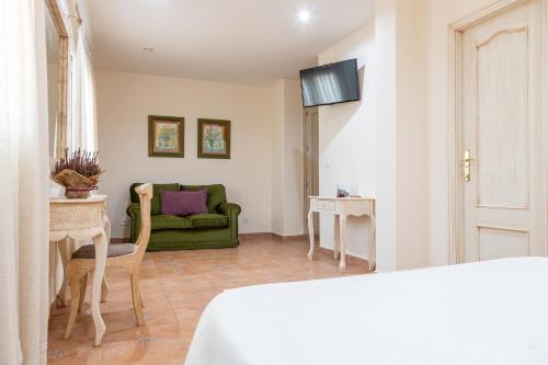 a room with a bed and a green couch at Puerta de Algadir in El Puerto de Santa María