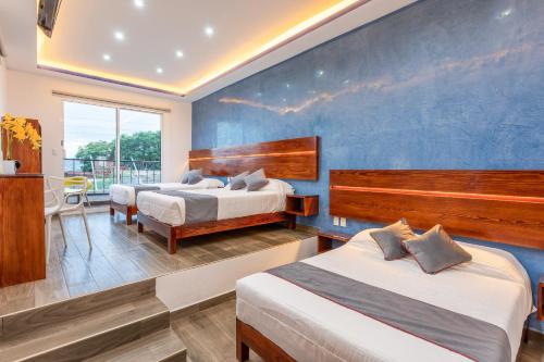 1 dormitorio con 2 camas y pared azul en Casa Dos Lunas, en Oaxaca City