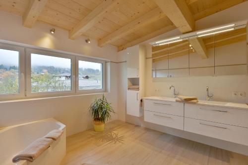 ein großes Bad mit einer Badewanne und einem Waschbecken in der Unterkunft Appartement Fuchs Ferdinand in Ellmau