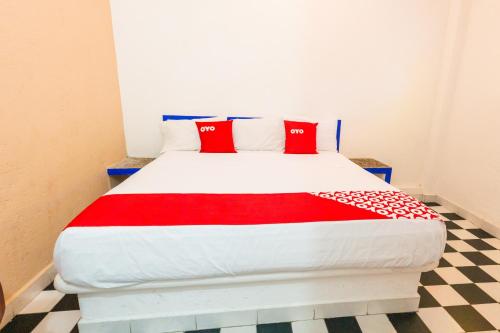 a bedroom with a bed with red pillows on it at Hotel Isis in Zihuatanejo
