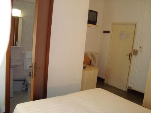 a small room with a bed and a bathroom at Giappone Inn Flat in Livorno