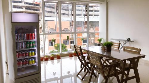 a dining room with a table and a refrigerator at Alexis KT Roomstay in Kuala Terengganu