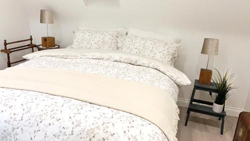 a bedroom with a white bed with white sheets and pillows at The Cottage get away in Saffron Walden