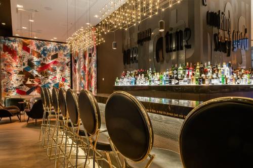 uma fila de cadeiras num bar com garrafas de licor em Motel One Frankfurt-Römer em Frankfurt