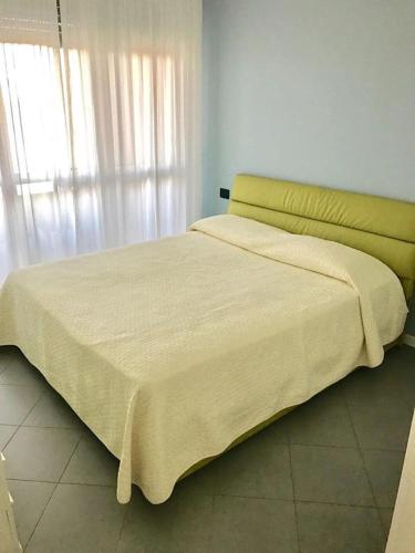 un grande letto con testiera gialla in una camera da letto di Panoramic Center Bovisa a Milano