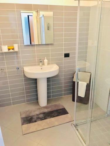 un bagno con lavandino e doccia con specchio di Panoramic Center Bovisa a Milano