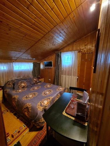 a bedroom with a bed and a table in it at VILA VALENCIA in Azuga