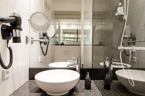 a bathroom with two sinks and a mirror at Motel One Frankfurt-Römer in Frankfurt