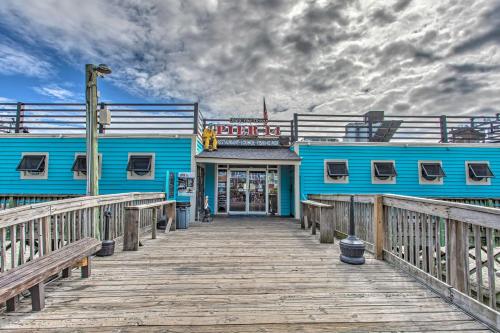 a blue building on a pier with a boardwalk at Steps to Boardwalk Condo with Pool in Myrtle Beach in Myrtle Beach