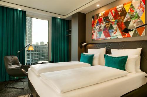 two beds in a hotel room with green curtains at Motel One Frankfurt-Römer in Frankfurt/Main