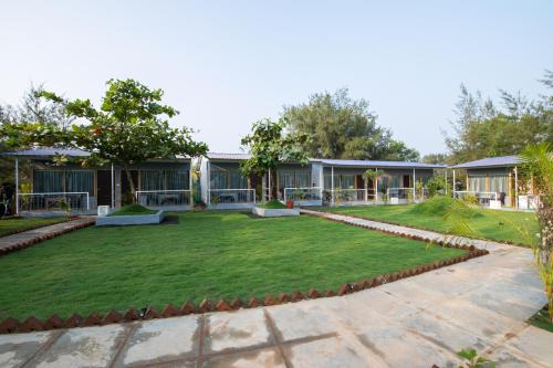 a large lawn in front of a house at Treebo Lands End Beach Resort Morjim in Morjim