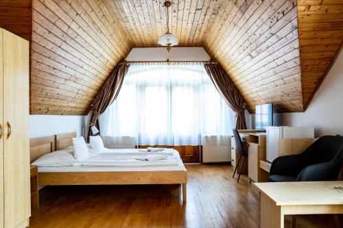 Habitación pequeña con cama y ventana en Aranybánya Panzió és Apartmanház en Telkibánya