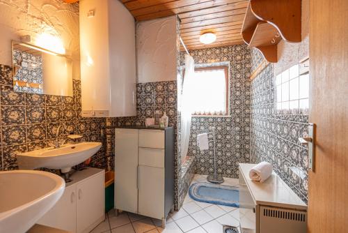 y baño con bañera, lavamanos y ducha. en Schanzerhütte, en Saalbach Hinterglemm