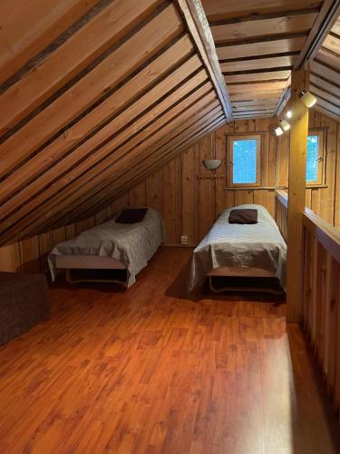 a bedroom with two beds in a wooden cabin at Kelotulkku Lodge in Muurame