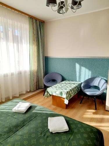 a room with two beds and a chair in it at Villa Iris in Kołobrzeg