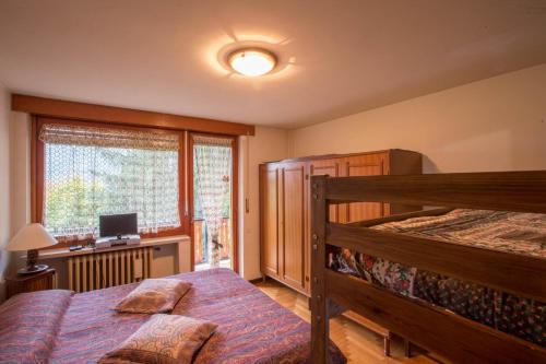 a bedroom with a bed and a desk and a window at ALTIDO Apt for 7 with Terrace and Exceptional Location in Courmayeur