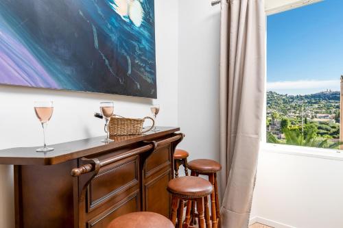 a bar with stools and a window with a view at Maison Carles BnB in La Colle-sur-Loup