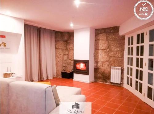 ein Wohnzimmer mit Couch und Kamin in der Unterkunft Cortegaça House in Vieira do Minho