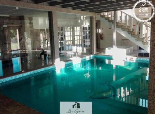 ein Swimmingpool mit blauem Wasser in einem Gebäude in der Unterkunft Cortegaça House in Vieira do Minho