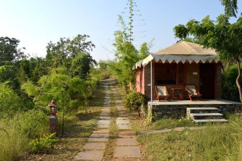 a small house with chairs on the side of a road at The Sky Imperial Jungle Camp Resort in Kumbhalgarh