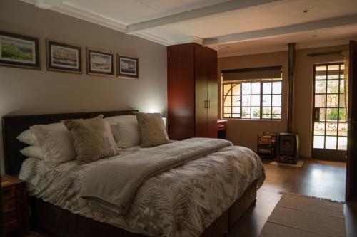 - une chambre avec un grand lit dans l'établissement Camdeboo Place, à Dullstroom