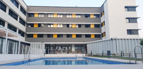 um edifício com piscina em frente a um edifício em Residencia Universitaria Campus Málaga em Málaga