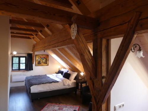 a bedroom with a bed in a room with wooden ceilings at Heuholzmühle Privatzimmer in Elixhausen