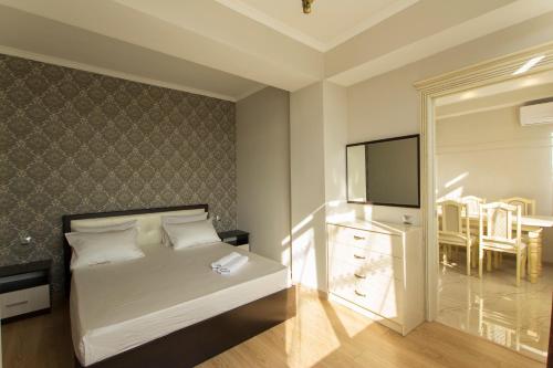 a bedroom with a bed and a flat screen tv at Residential Сomplex Central 270 in Almaty