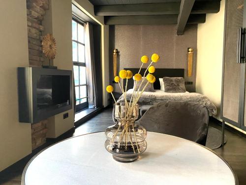 a vase with yellow flowers on a table in a room at Hotel de Prince in Nijmegen