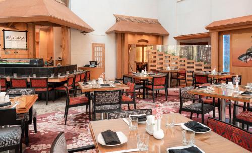 a restaurant with tables and chairs in a room at Holiday Inn Kuwait by IHG in Kuwait
