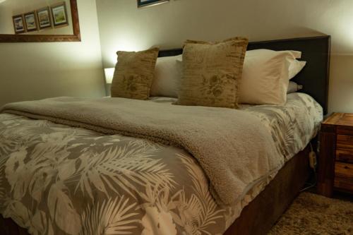 a bedroom with a large bed with pillows at Camdeboo Place in Dullstroom