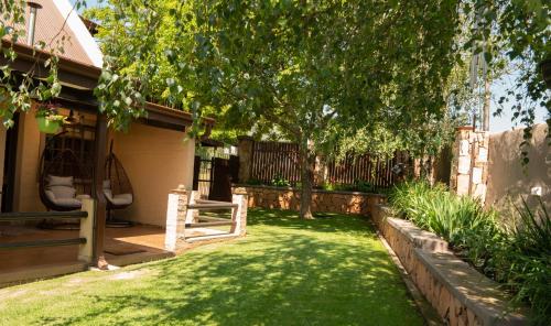 a yard with a fence and a bench in the grass at Camdeboo Place in Dullstroom