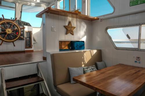 a dining room in a boat with a wooden table at Barco Casa Marina Fuzeta in Fuzeta