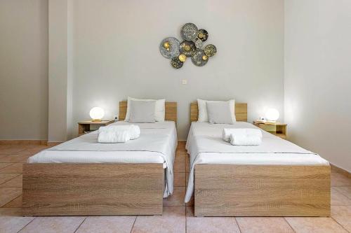 two beds in a room with a clock on the wall at Faro Del Porto in Póros Kefalonias