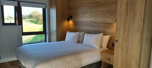 een slaapkamer met een wit bed en een raam bij Murrisk Apartments - Self Catering in Westport