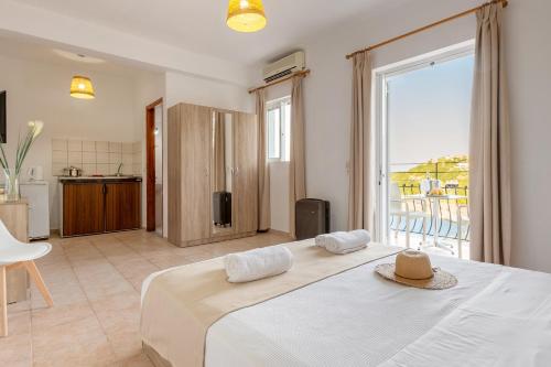 sypialnia z dużym łóżkiem i dużym oknem w obiekcie Faro Del Porto w mieście Poros