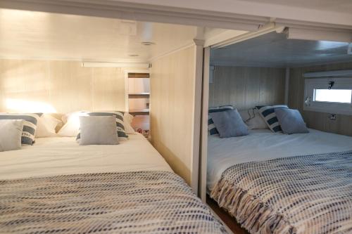 a bedroom with two beds and a window at Barco Casa Marina Fuzeta in Fuzeta