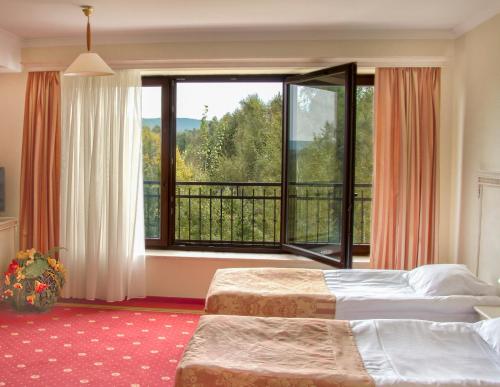 a hotel room with two beds and a large window at Hotel Stodółka in Kielce