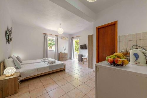 a bedroom with a bed and a kitchen with a bowl of fruit at Faro Del Porto in Póros Kefalonias