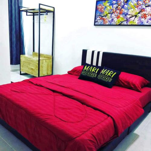 a bedroom with a red bed with a red blanket at MARI Residence in Kuala Terengganu