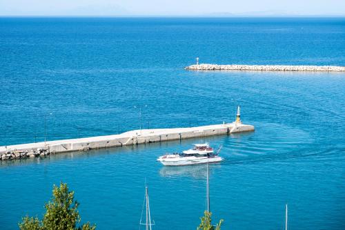 a small boat in the water next to a dock at Faro Del Porto in Póros Kefalonias
