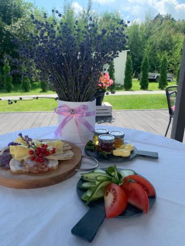 une table avec des assiettes de nourriture et une étrave rose dans l'établissement Pensjonat Lawendowy Zakątek, à Zabłudów